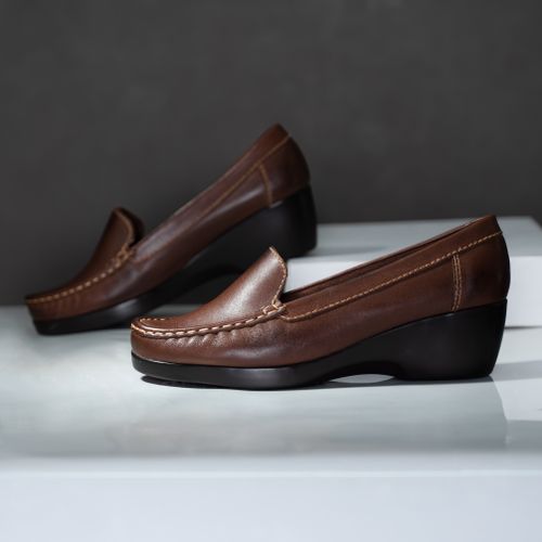Free Stylish brown leather moccasins with wedge heels perfect for formal or casual wear. Stock Photo