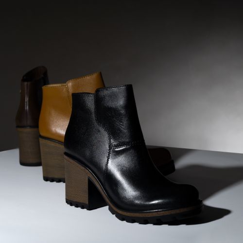 Free Elegant leather ankle boots with block heels showcased in a minimalist studio setting. Stock Photo