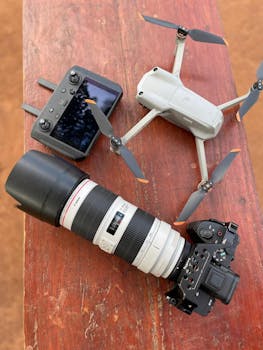 Camera and drone equipment on a wooden surface, ready for action.