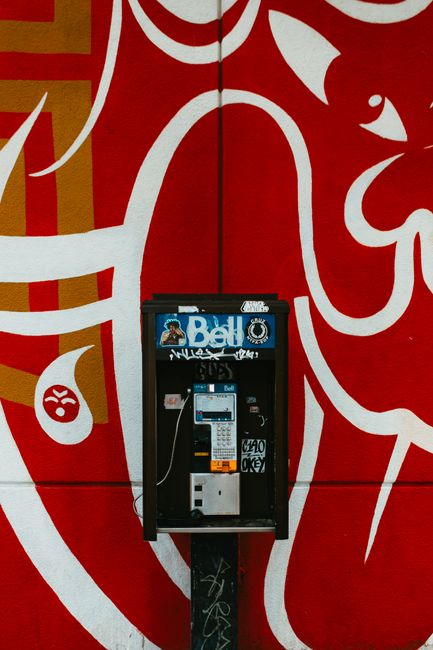 Street art mural with an old payphone in downtown Montreal, showcasing bold graffiti designs and urban vibes.
