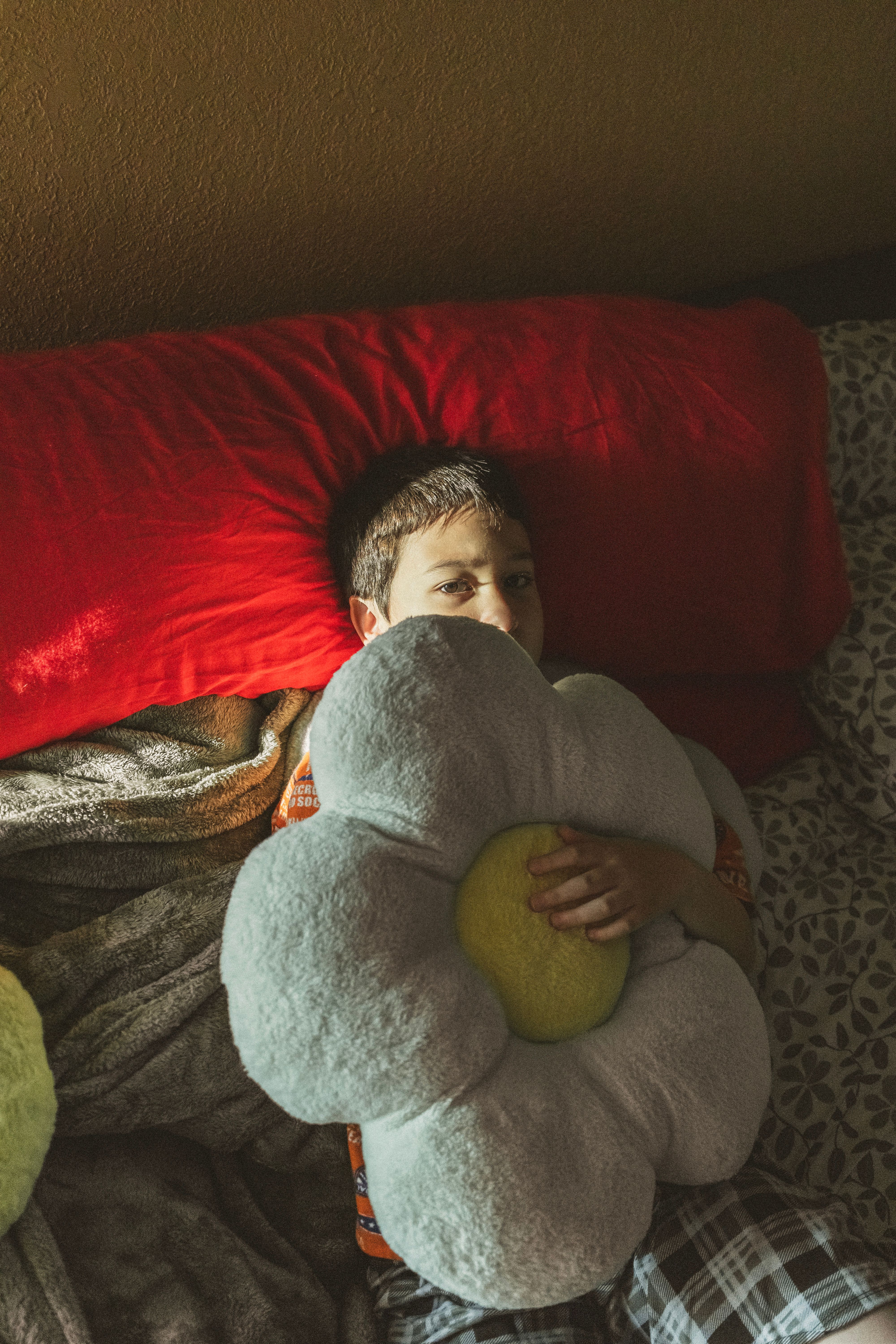 Child resting comfortably with a soft pillow in a cozy bedroom setting.