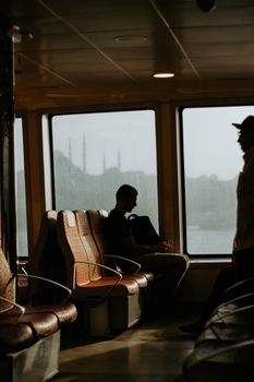 A silhouette of a man sitting on a ferry in İstanbul, creating a serene travel moment.