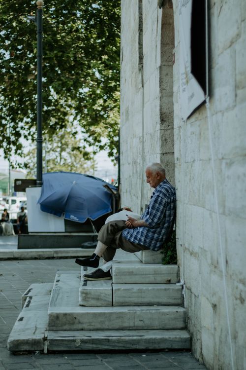 Free Elderly man reading on a street corner in İstanbul, Türkiye, showcasing urban relaxation. Stock Photo