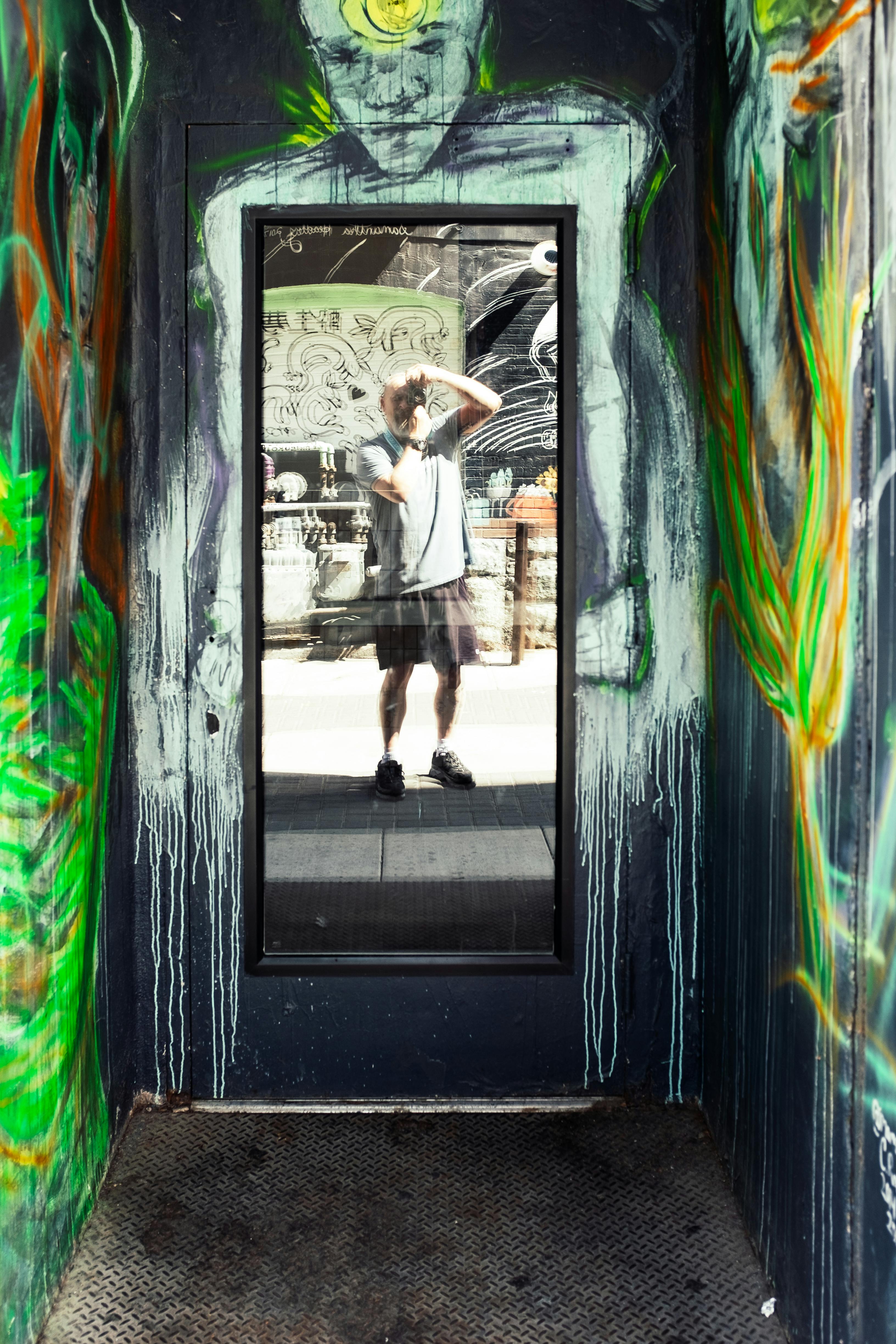 a man standing in front of a door with graffiti on it