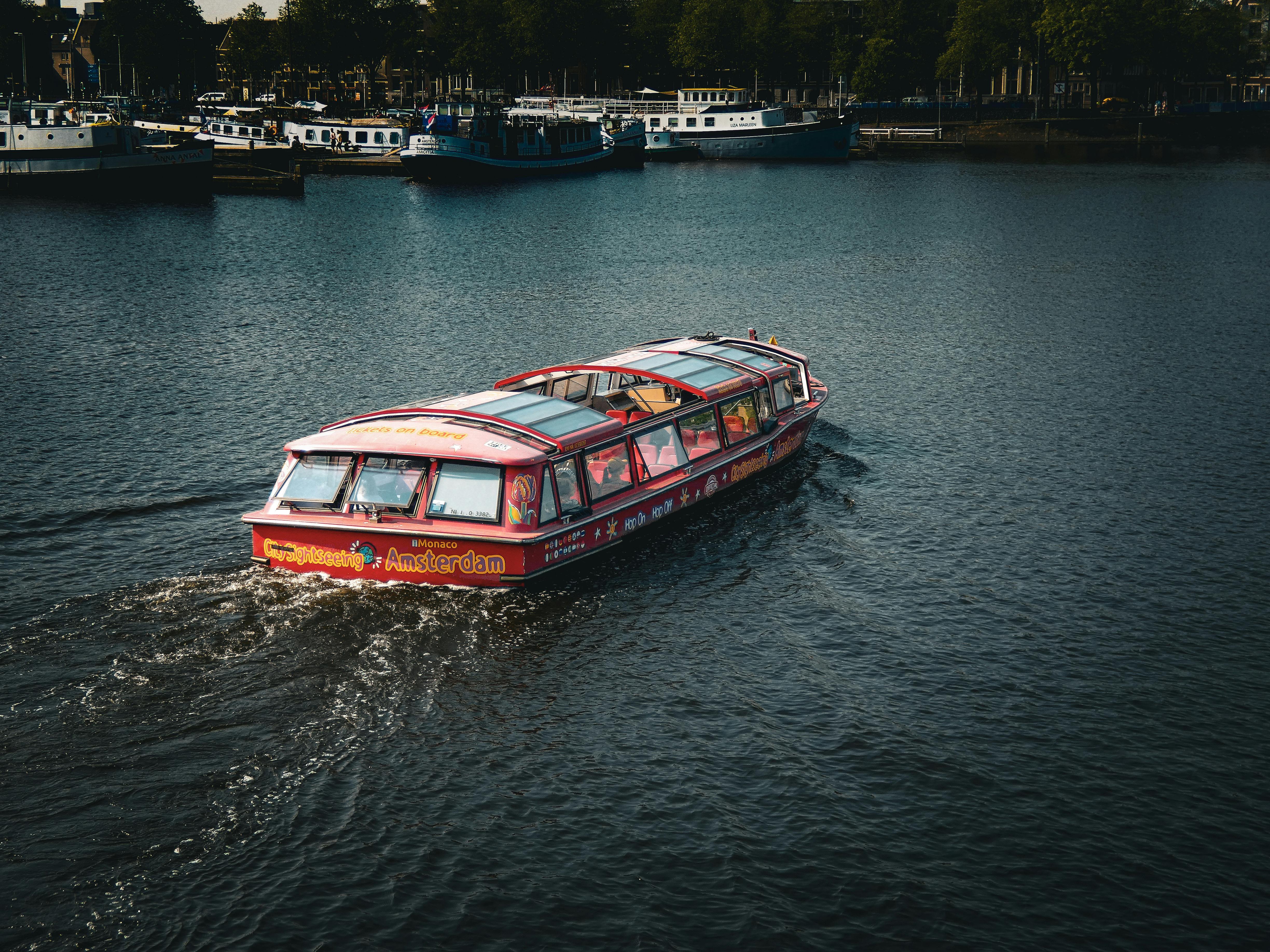 a boat traveling down a river with a lot of people on it