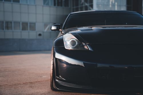 Free Close-up of a modern black sports car parked in an urban environment, showcasing sleek design. Stock Photo