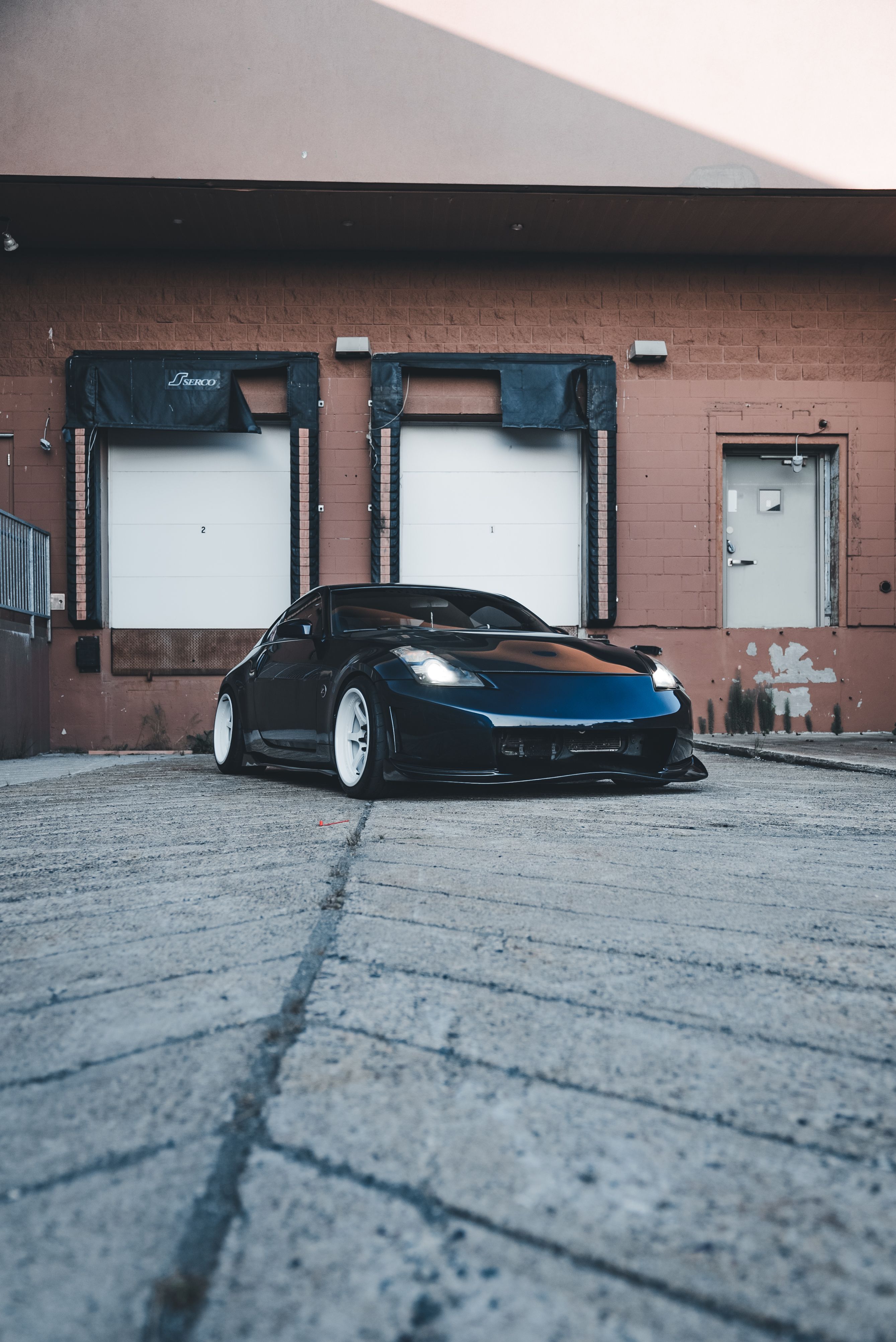 A black sports car parked in front of a building · Free Stock Photo