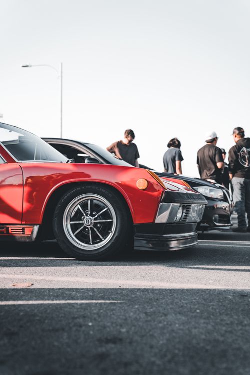 Free A dynamic scene featuring a red sports car and people gathered, capturing automotive passion. Stock Photo