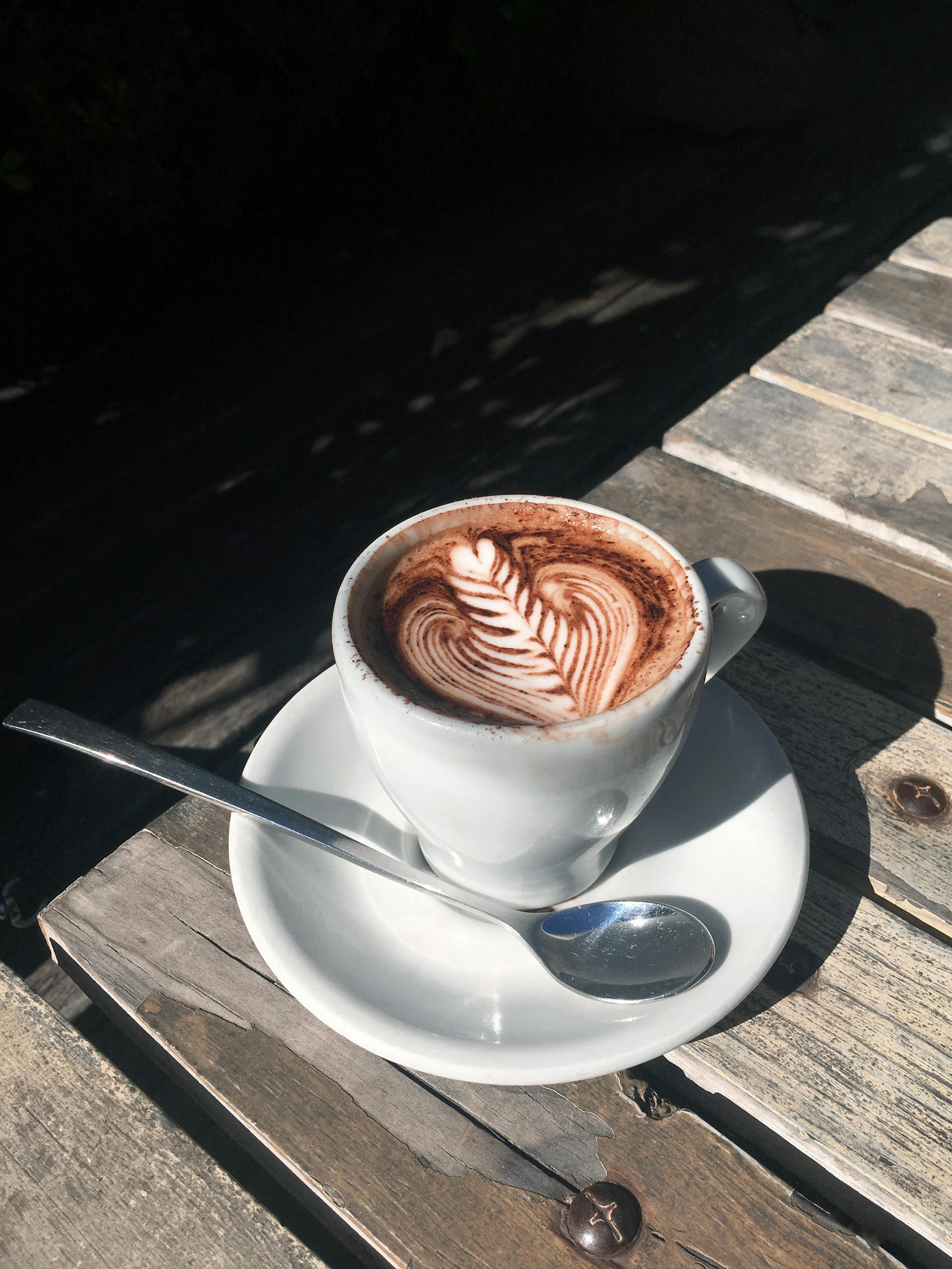 a cup of cappuccino on wooden table