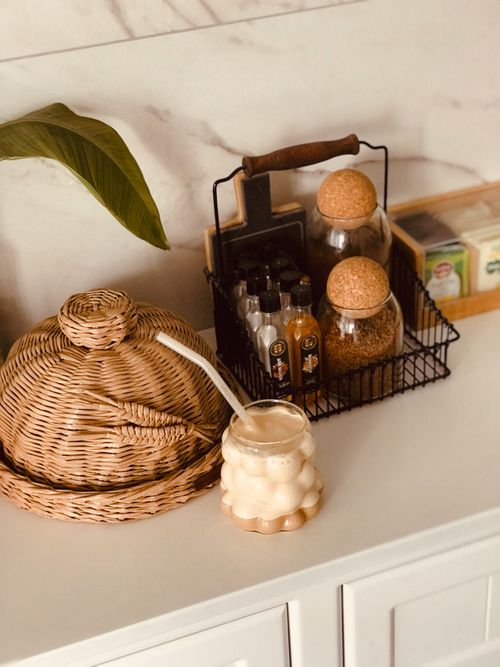 Free Cozy kitchen counter with a wicker basket, beverages, and kitchenware. Stock Photo