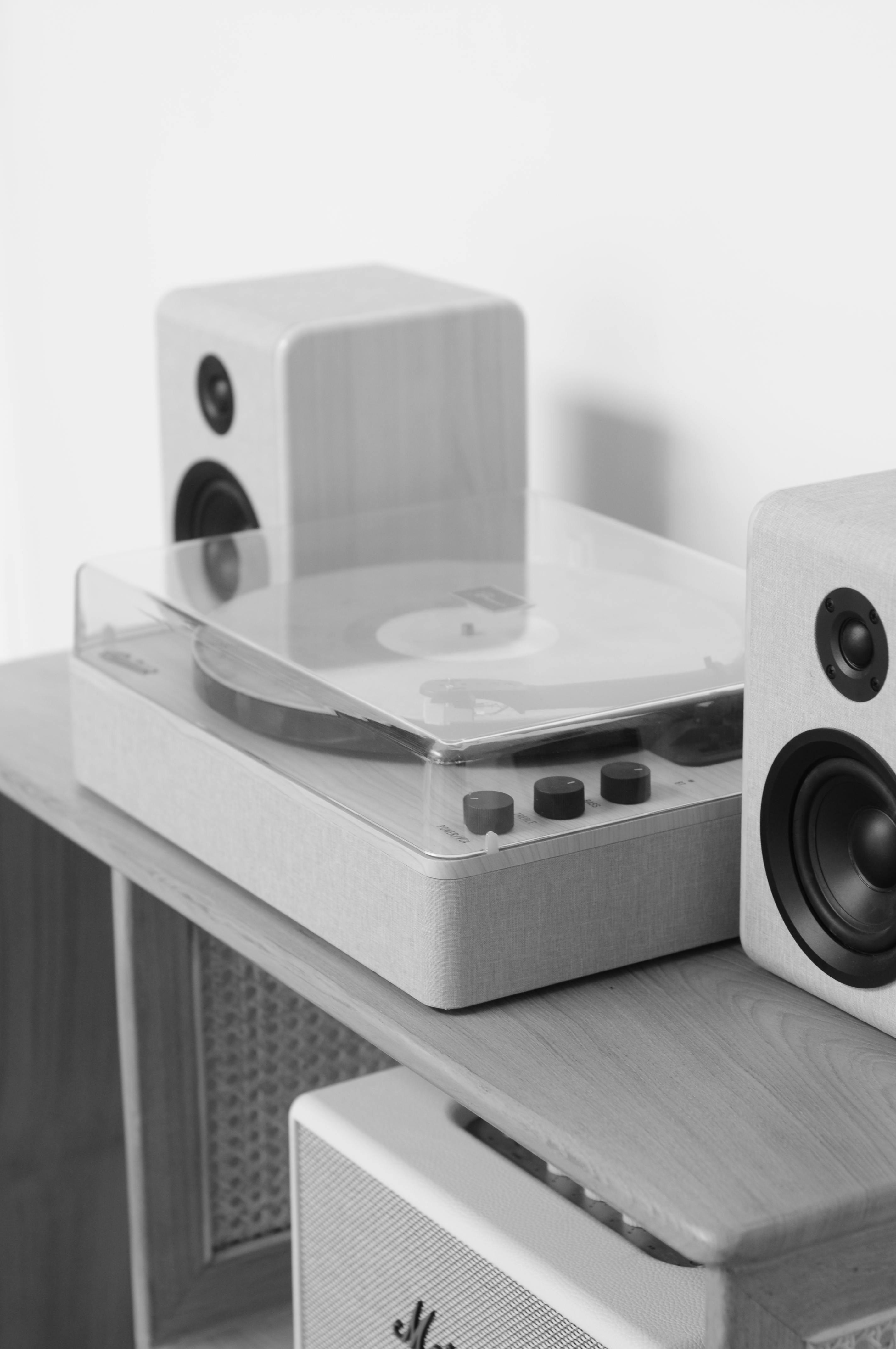 Stylish black and white photo of a vinyl record player with stereo speakers.