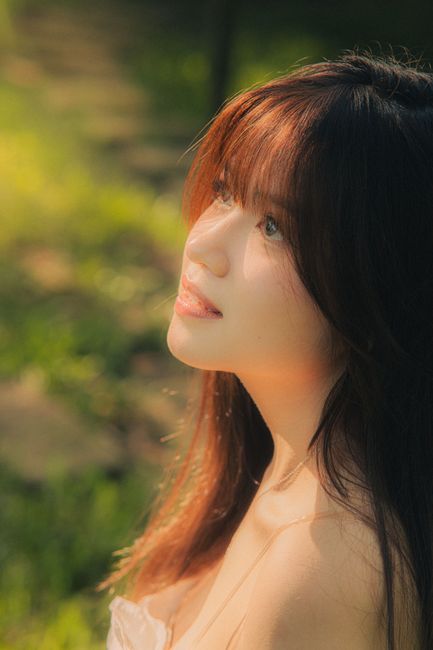 Side view portrait of an Asian woman in sunlight, capturing beauty and serenity.