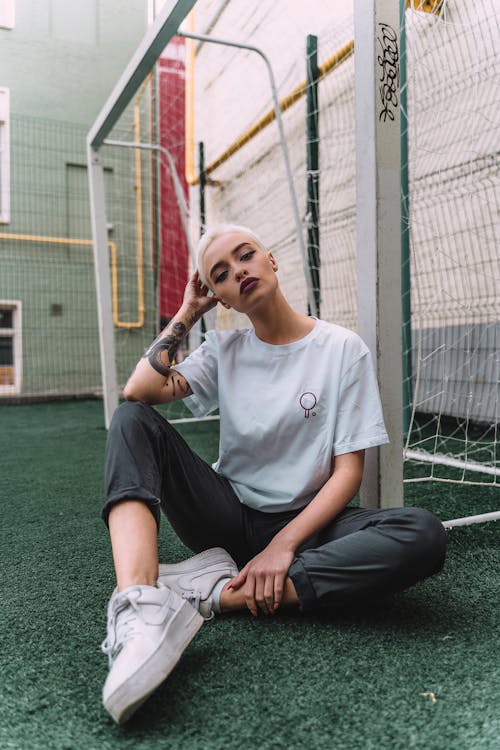 Free Woman Sitting Beside Goalie Net Stock Photo