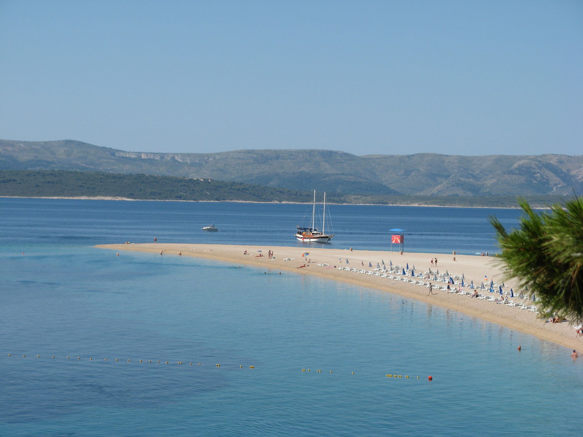 Stunning panoramic beach view of Zlatni Rat Beach in Croatia with clear waters and sunny skies.