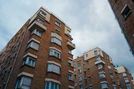 Urban brick apartment buildings under a cloudy sky, showcasing city living architecture.