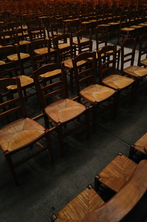 Free Multiple rows of wooden chairs setup in a large indoor hall, unoccupied and orderly arranged. Stock Photo