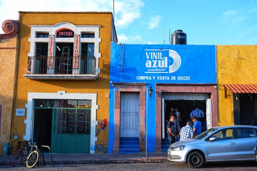 Lively streetscape of Santiago de Querétaro with vibrant storefronts and people.