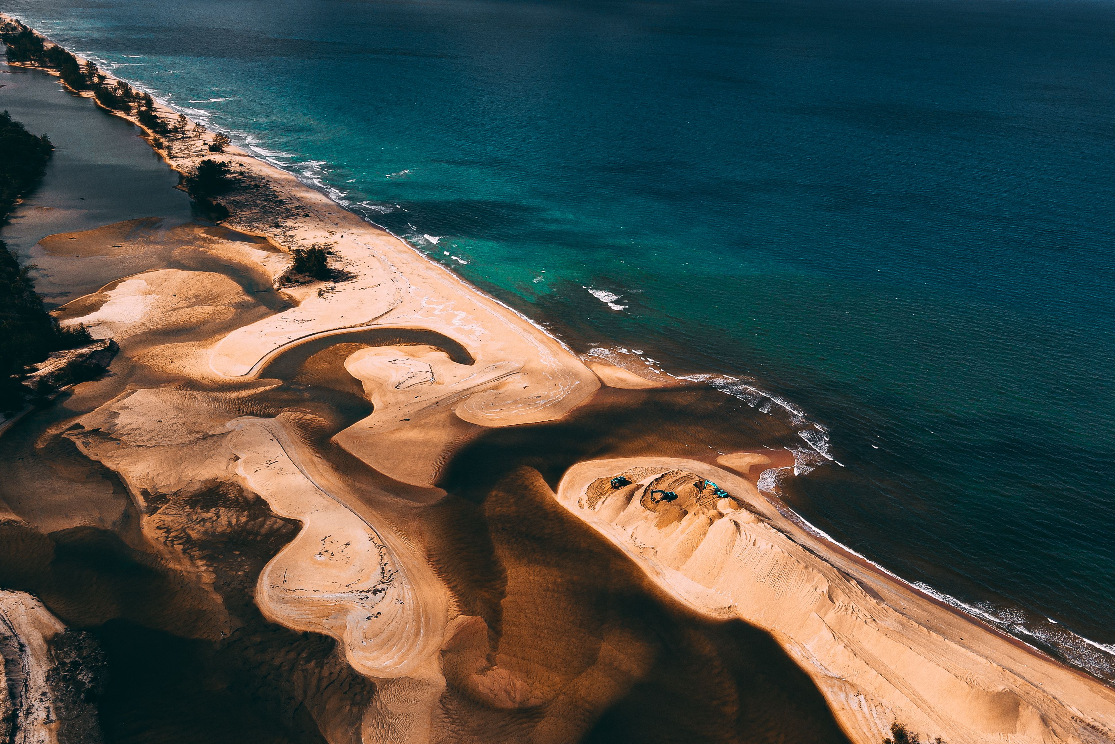 Stunning aerial shot of a sandy beach meeting the azure ocean, capturing natural beauty and tranquility.