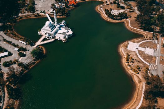Stunning aerial view of an isolated mosque on a tranquil lake island with surrounding landscape.