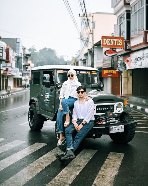 Free Stylish young couple in urban area posing with a classic Toyota SUV on a rainy day. Stock Photo