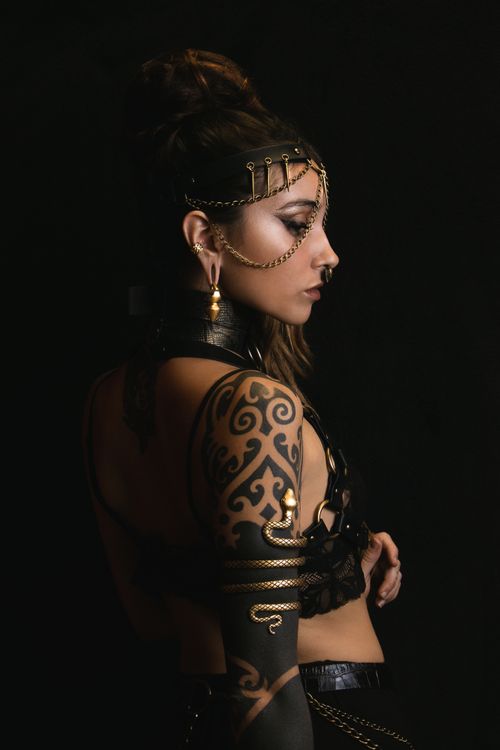 Free Portrait of a young woman with intricate tattoos and fashion accessories, exuding glamour and style. Stock Photo