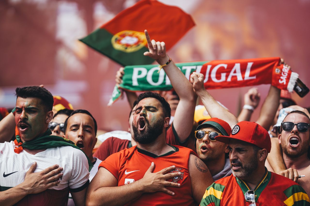 passionate portugal football supporters cheering with flags and scarve