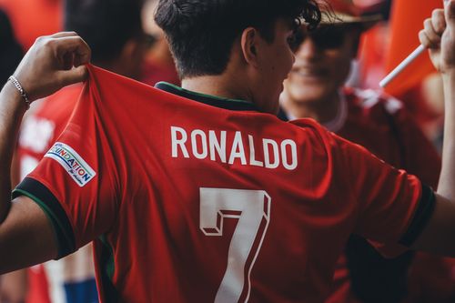 Free A passionate soccer fan wearing a Ronaldo jersey celebrates at a sports event. Stock Photo