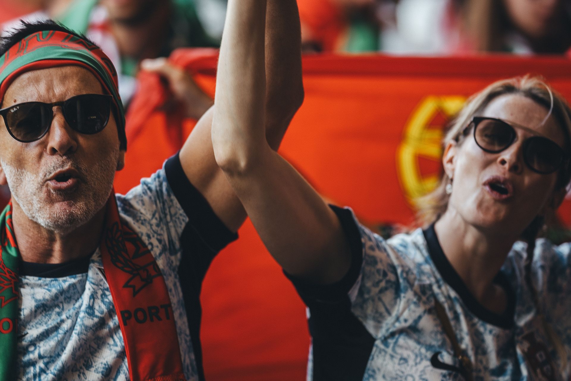Enthusiastic sports fans cheering with passion at an outdoor event.