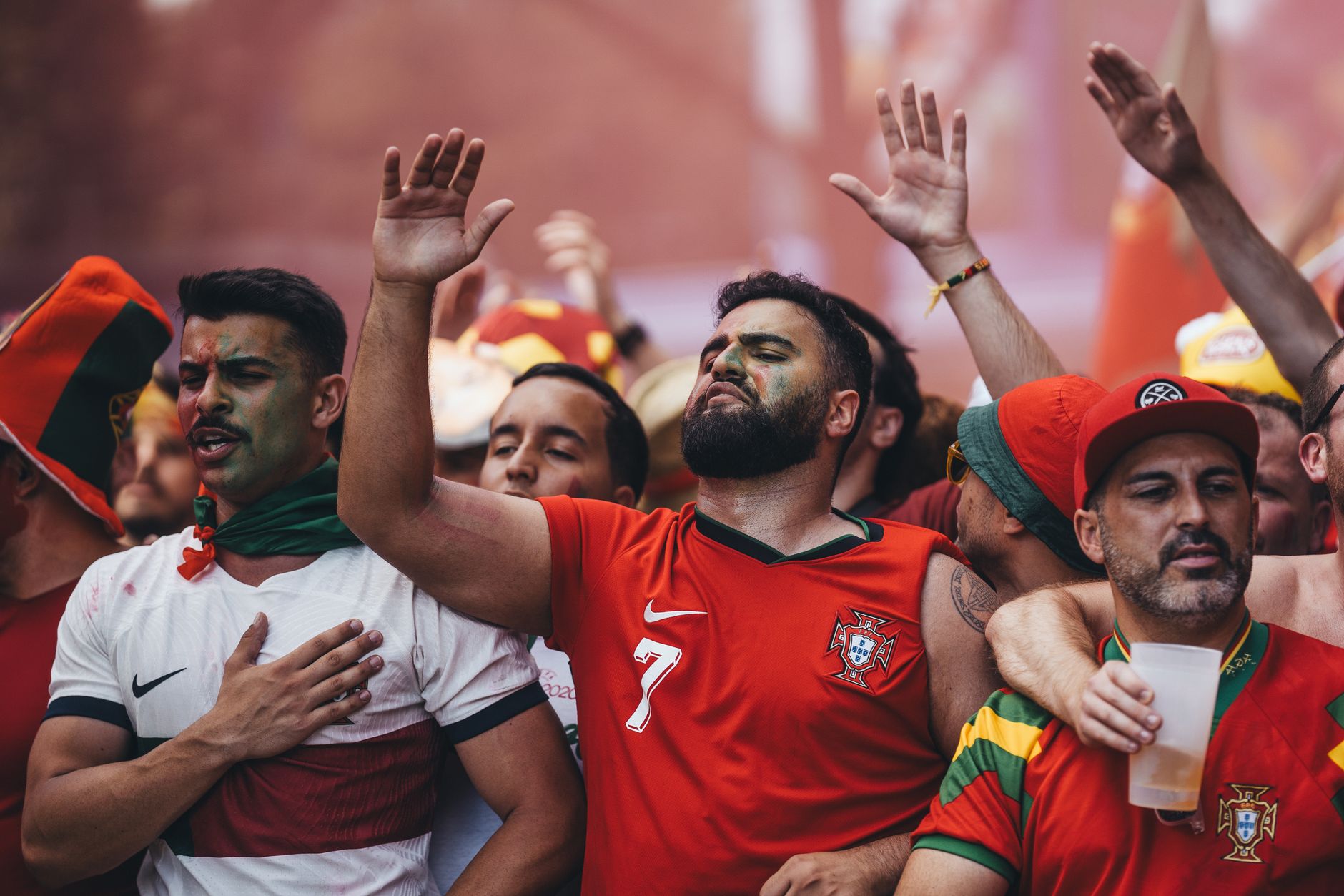 Excited group of soccer fans passionately cheering at a game, showing their vibrant team spirit.
