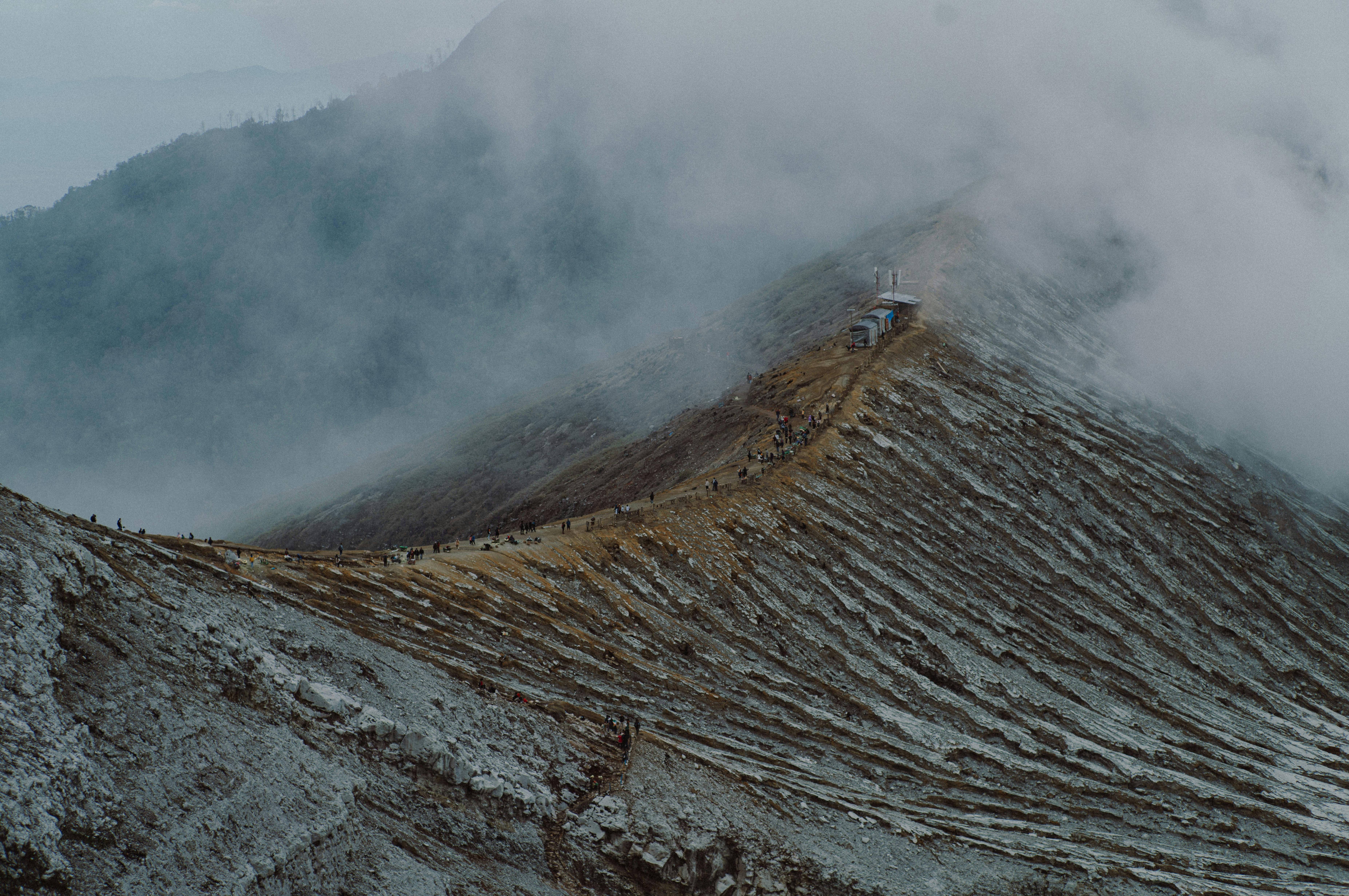 Majestic view of a foggy mountain ridge with visible volcanic terrain in East Java, Indonesia.