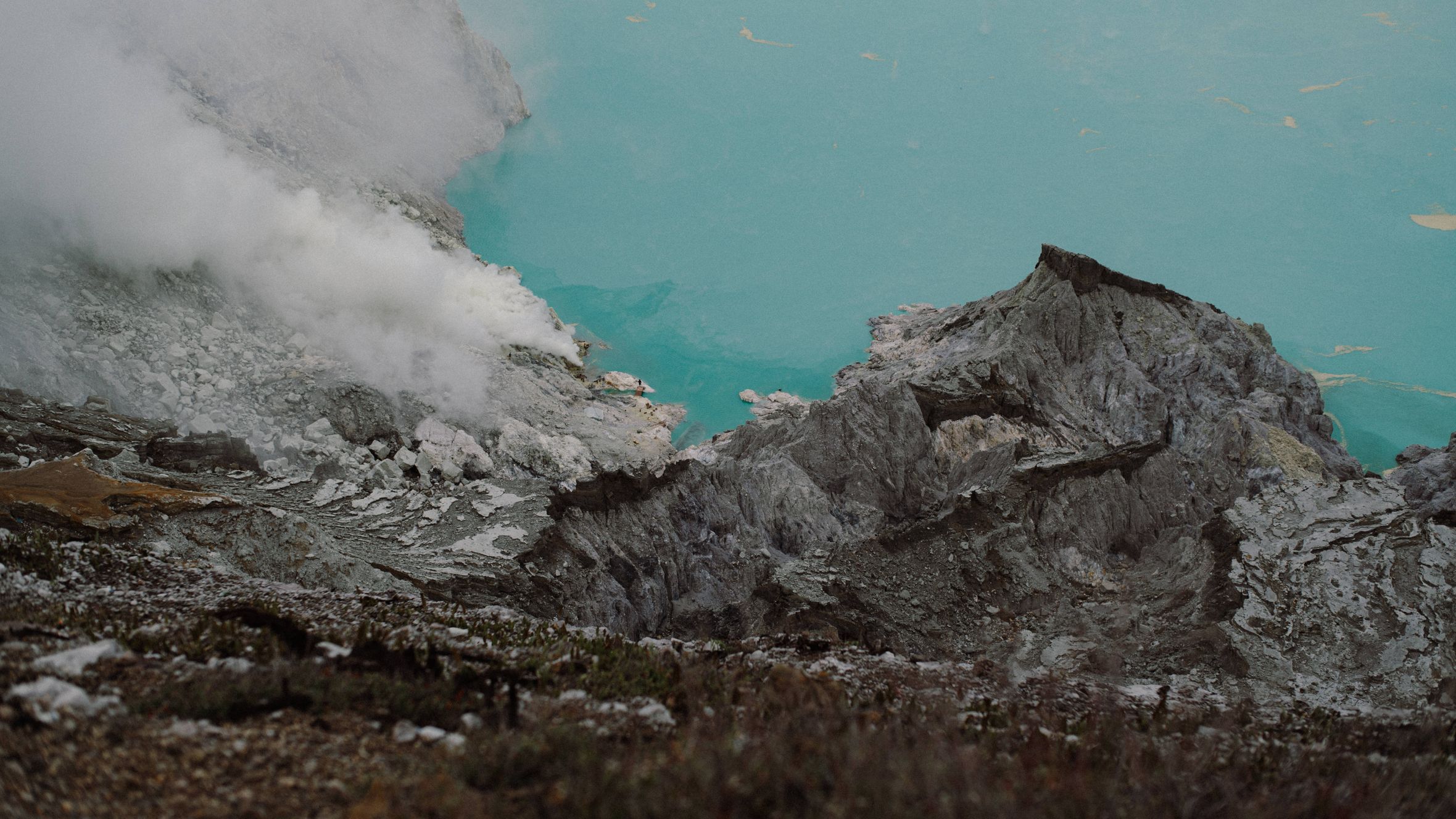 A stunning view of the Ijen volcano crater lake with steaming sulfur vents in East Java, Indonesia.
