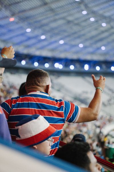 Supporter raising an arm in the stand, by Cristiano Junior on Pexels