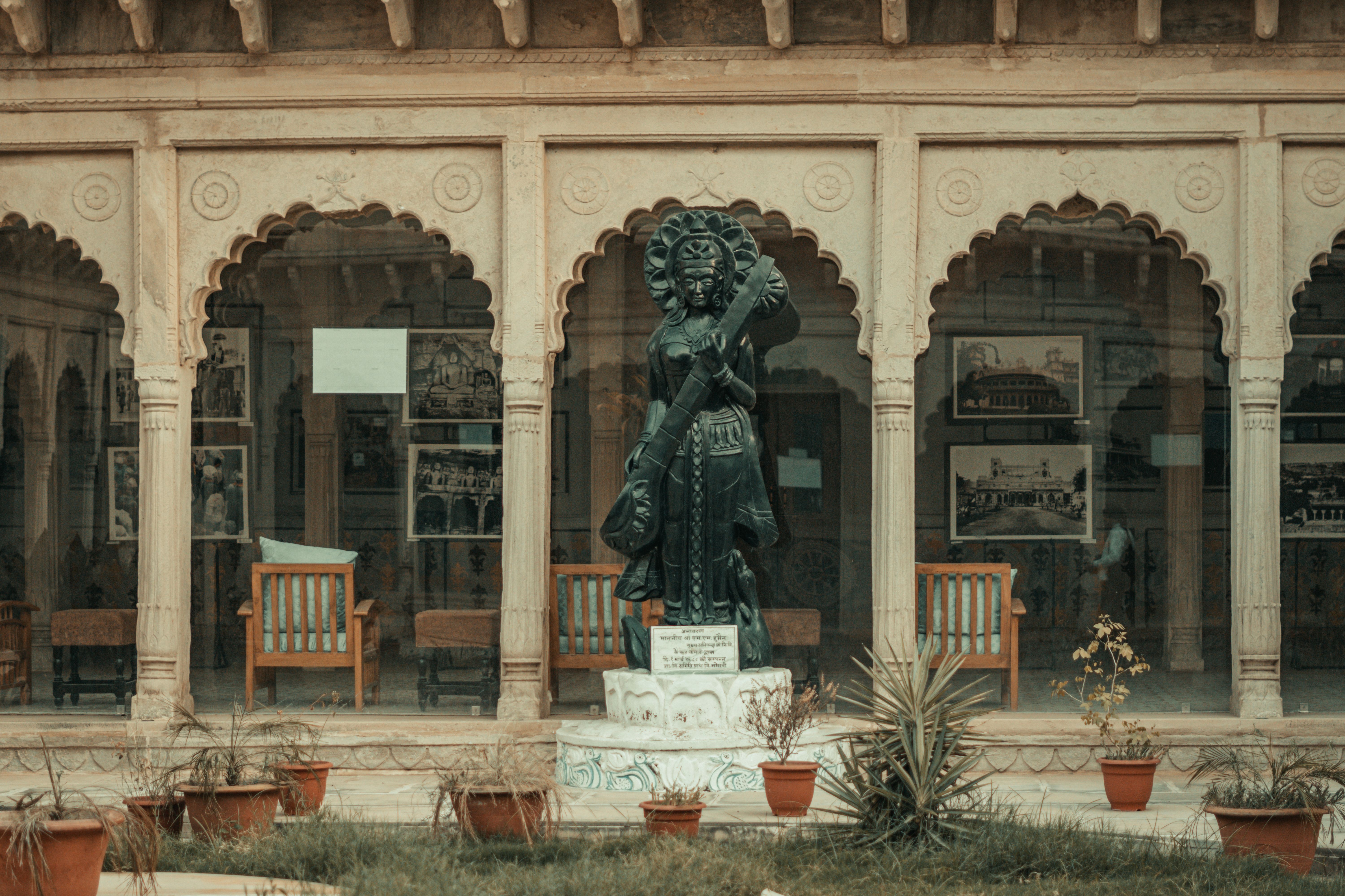 Lamplit sandstone courtyard of a restored haveli with carved arches and a jharokha balcony