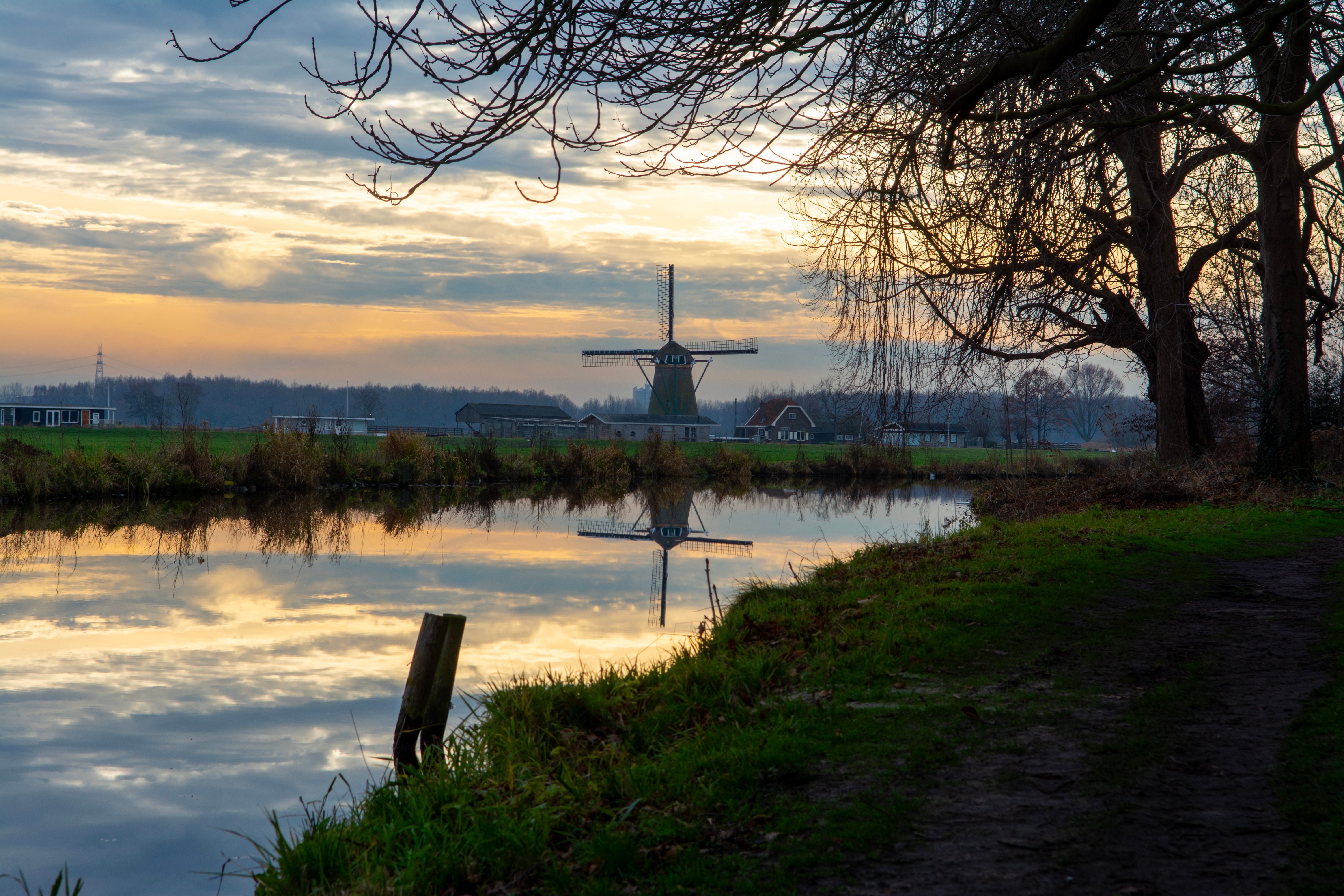 Traditional Windmill Reflecting in a Lake at Dusk · Free Stock Photo