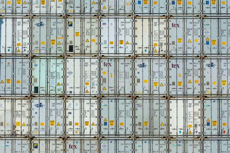 Rows of stacked import shipping containers at a terminal