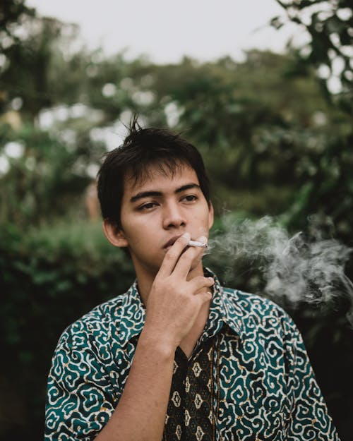 Free Man Smoking Near Trees Stock Photo