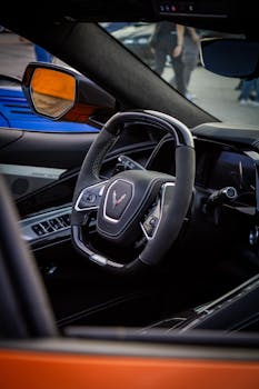 Luxury sports car interior featuring a sleek steering wheel and modern dashboard design.