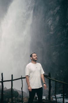 A man standing by the majestic Kapuzbaşı Waterfall in Kayseri, Türkiye, embracing nature's power.