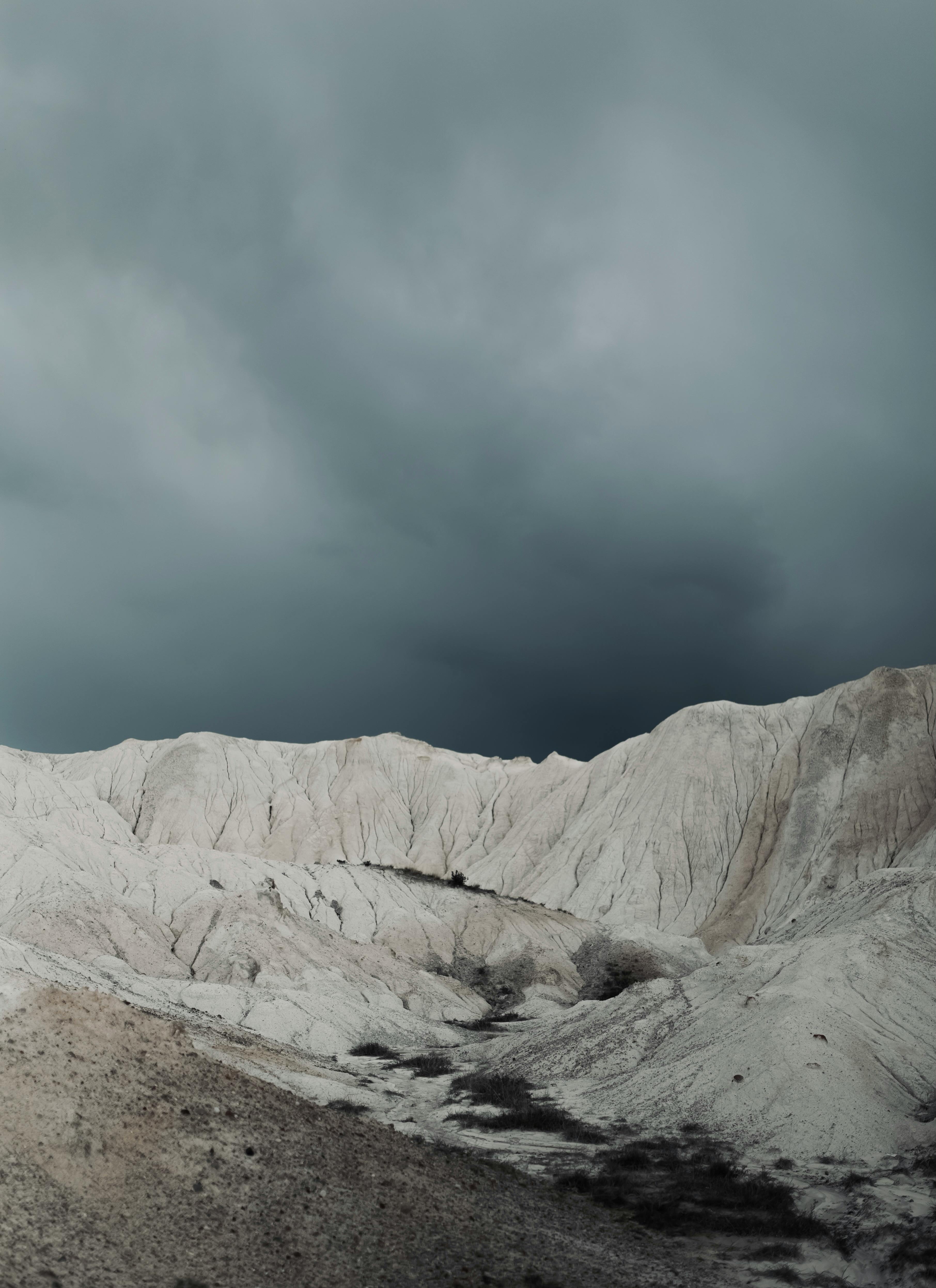 Captivating view of Göreme's distinct white rock formations under a dramatic sky.