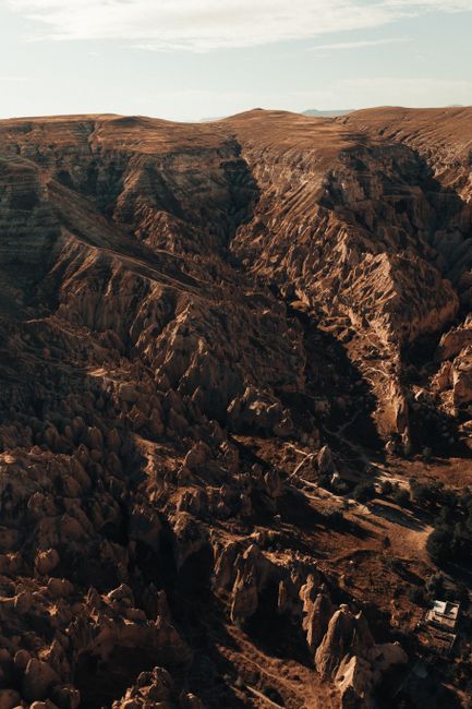 A stunning aerial view of Göreme's unique rock formations and canyons at sunset in Türkiye.