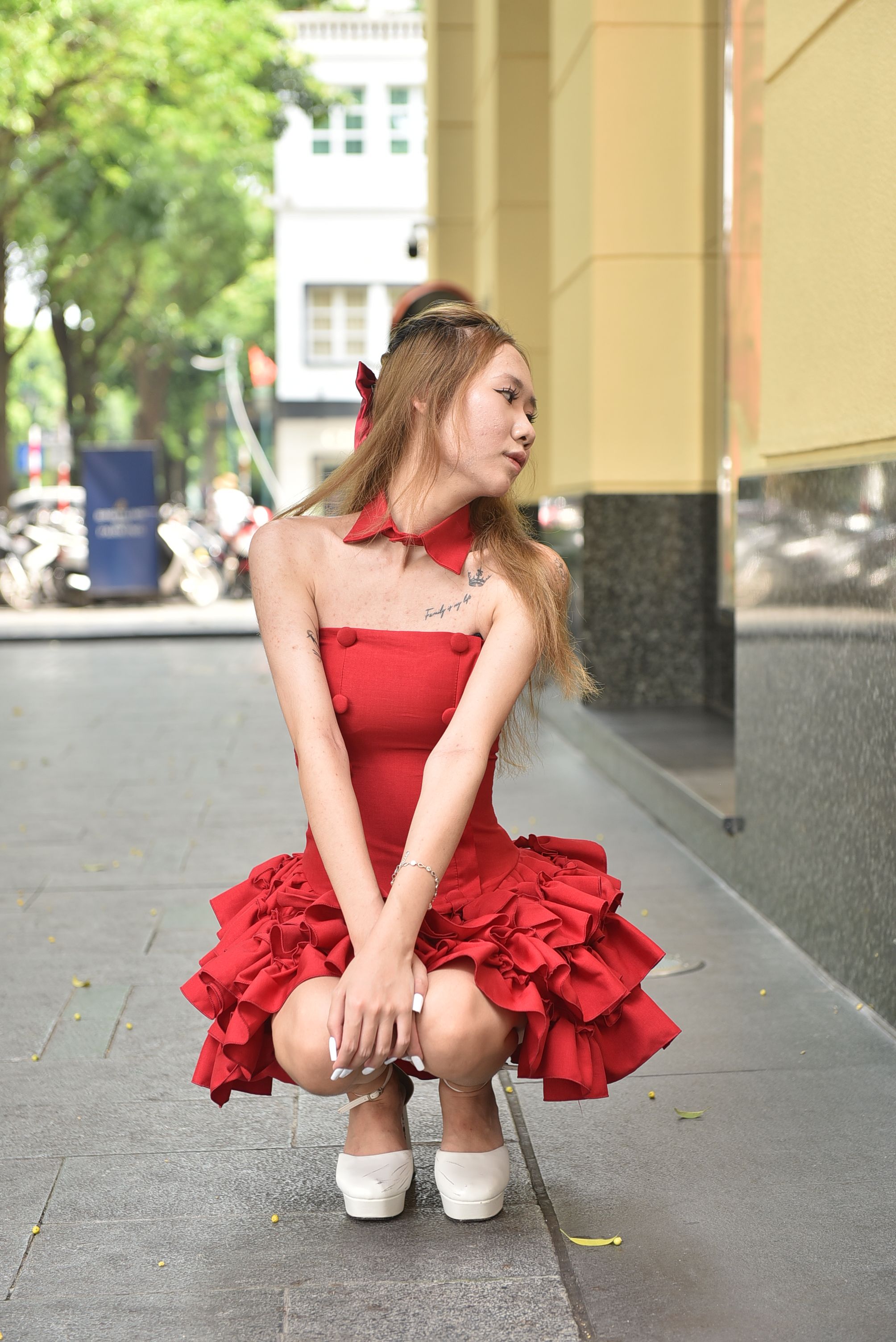 A Young Woman in a Red Dress Posing on the Sidewalk · Free Stock Photo