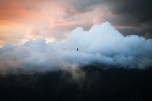 Majestic view of Christ the Redeemer surrounded by dramatic clouds at sunset in Rio.
