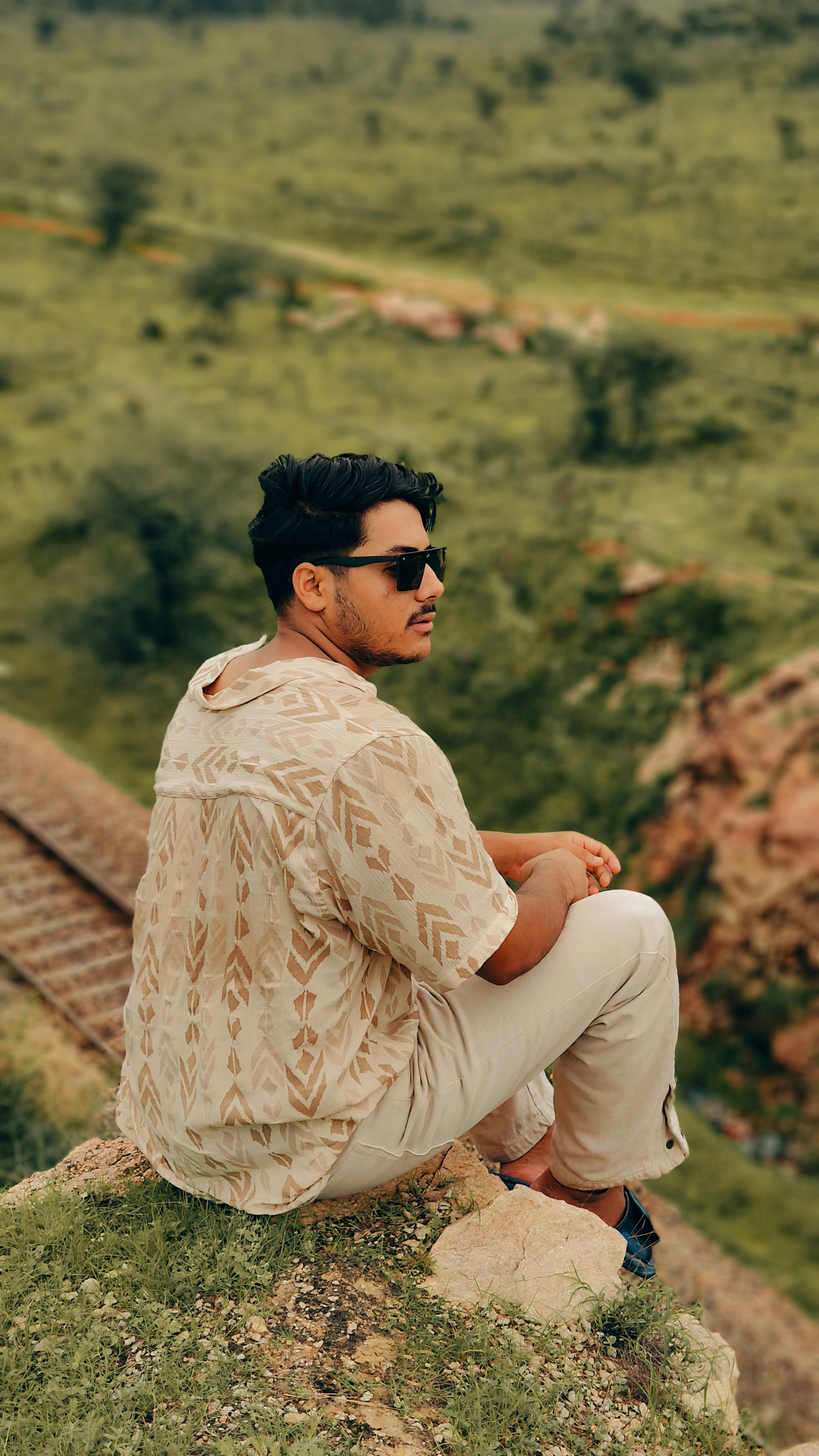 Portrait of a man sitting on a cliff in Jaipur, India, enjoying the summer scenery.