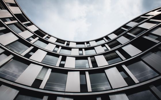 Stunning upward view of a modern curved building in Hamburg. A blend of glass and steel.