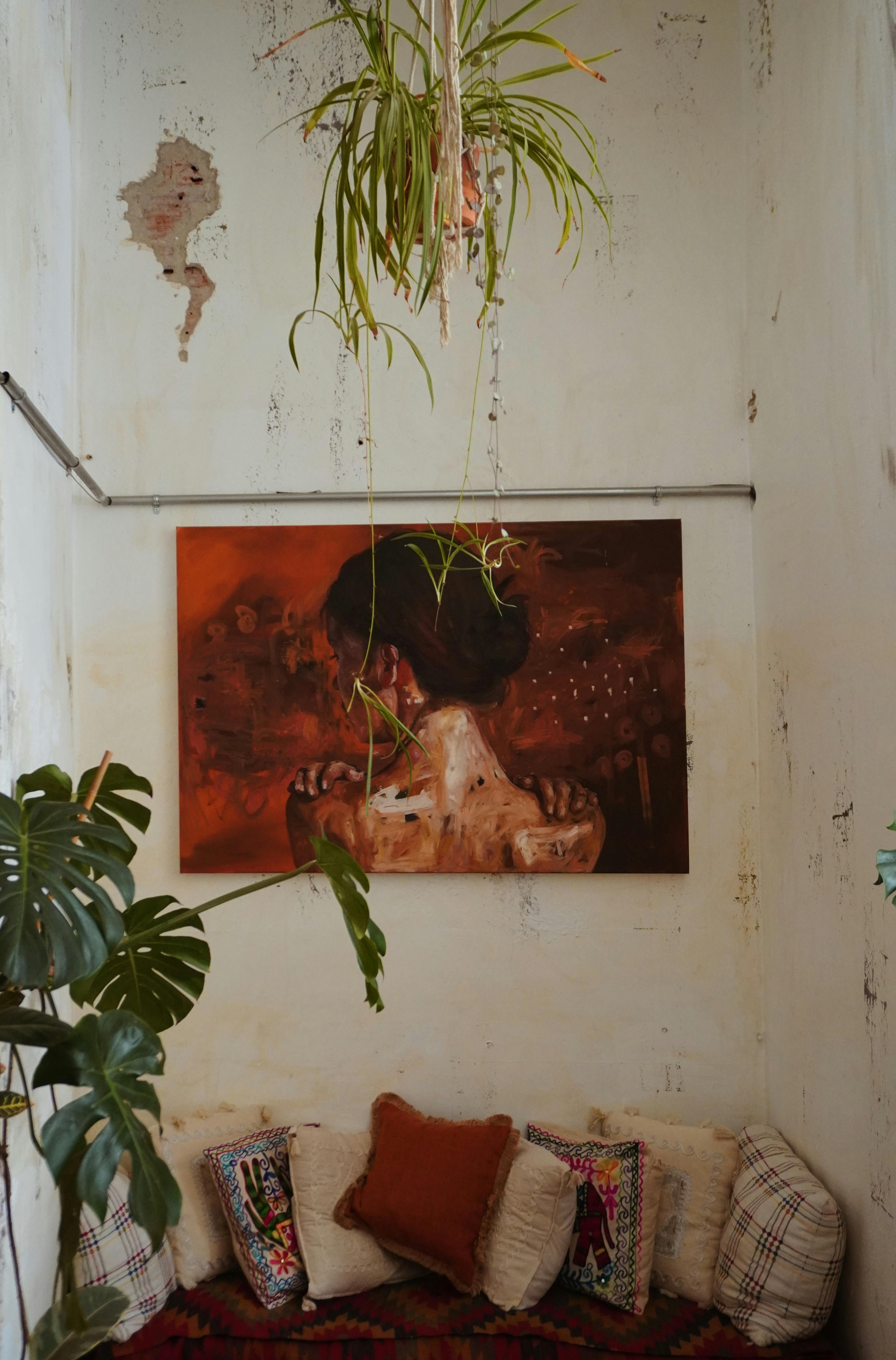 Free Vintage room with artwork, hanging plants, and cozy seating. Perfect for home interior design inspiration. Stock Photo