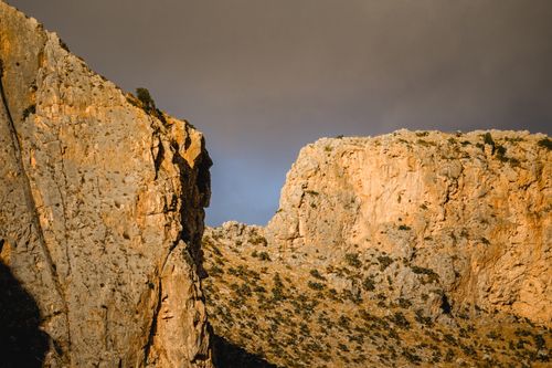 Free Stunning view of rocky cliffs illuminated by warm sunset light in an arid landscape. Stock Photo