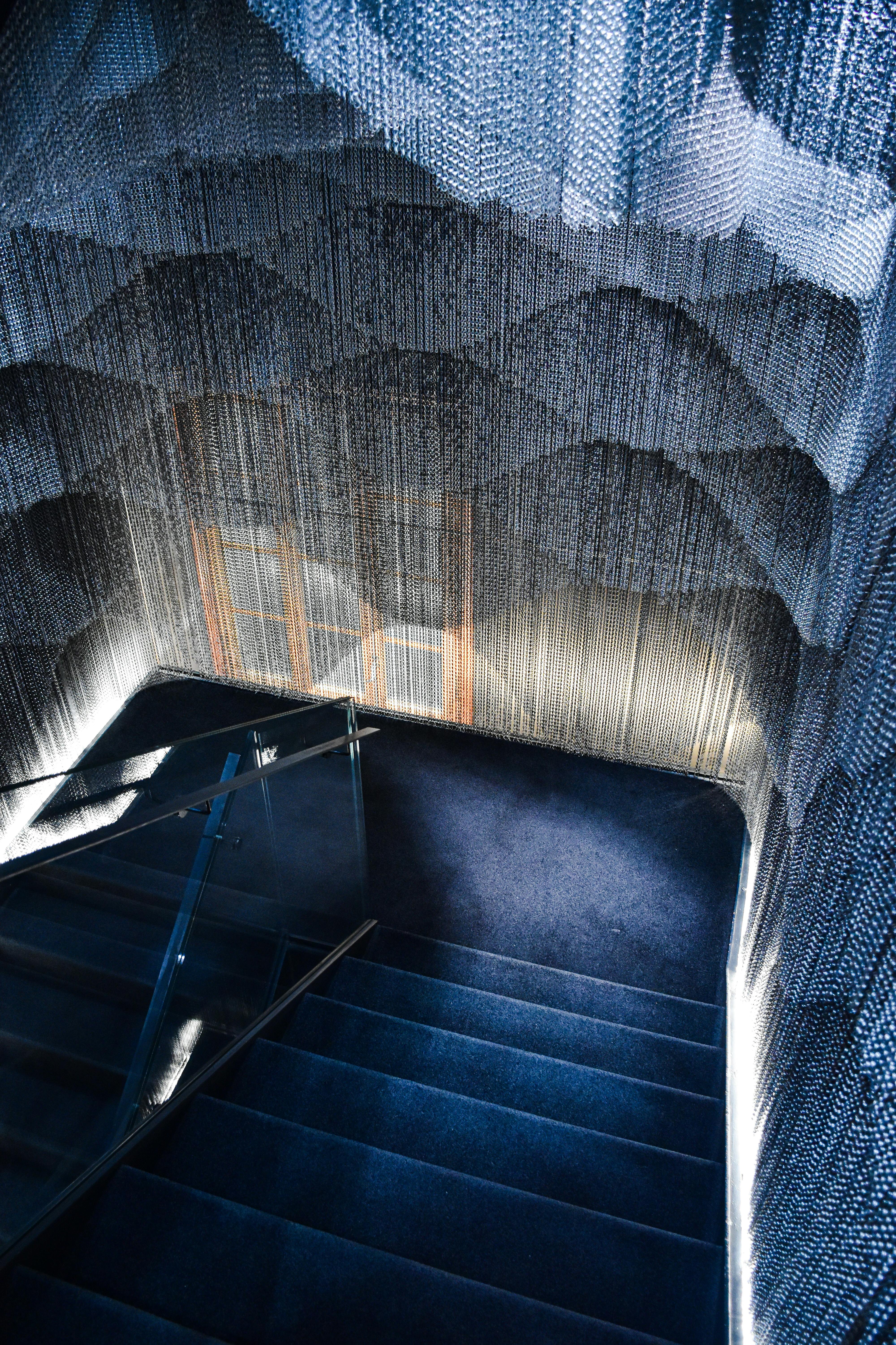 a staircase with a blue carpet and a large net