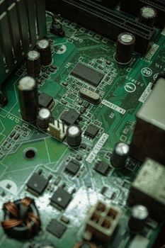 Detailed view of electronic components on a green circuit board surface.