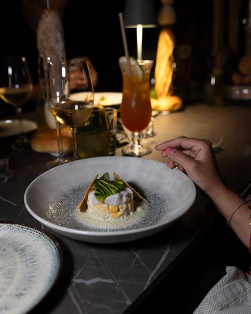 Free A sophisticated dining experience showcasing a gourmet dish with elegant lighting and drinks. Stock Photo