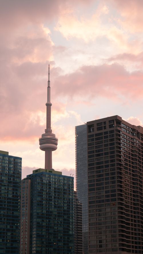 Free Stunning sunset view of Toronto skyline featuring the CN Tower amidst high-rise buildings. Stock Photo